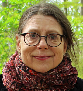 Jenny Wetterling, kvinna med brunt hår och glasögon samt halsduk.